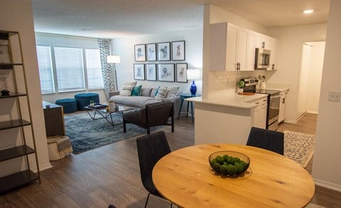 an open living room and kitchen with a dining table